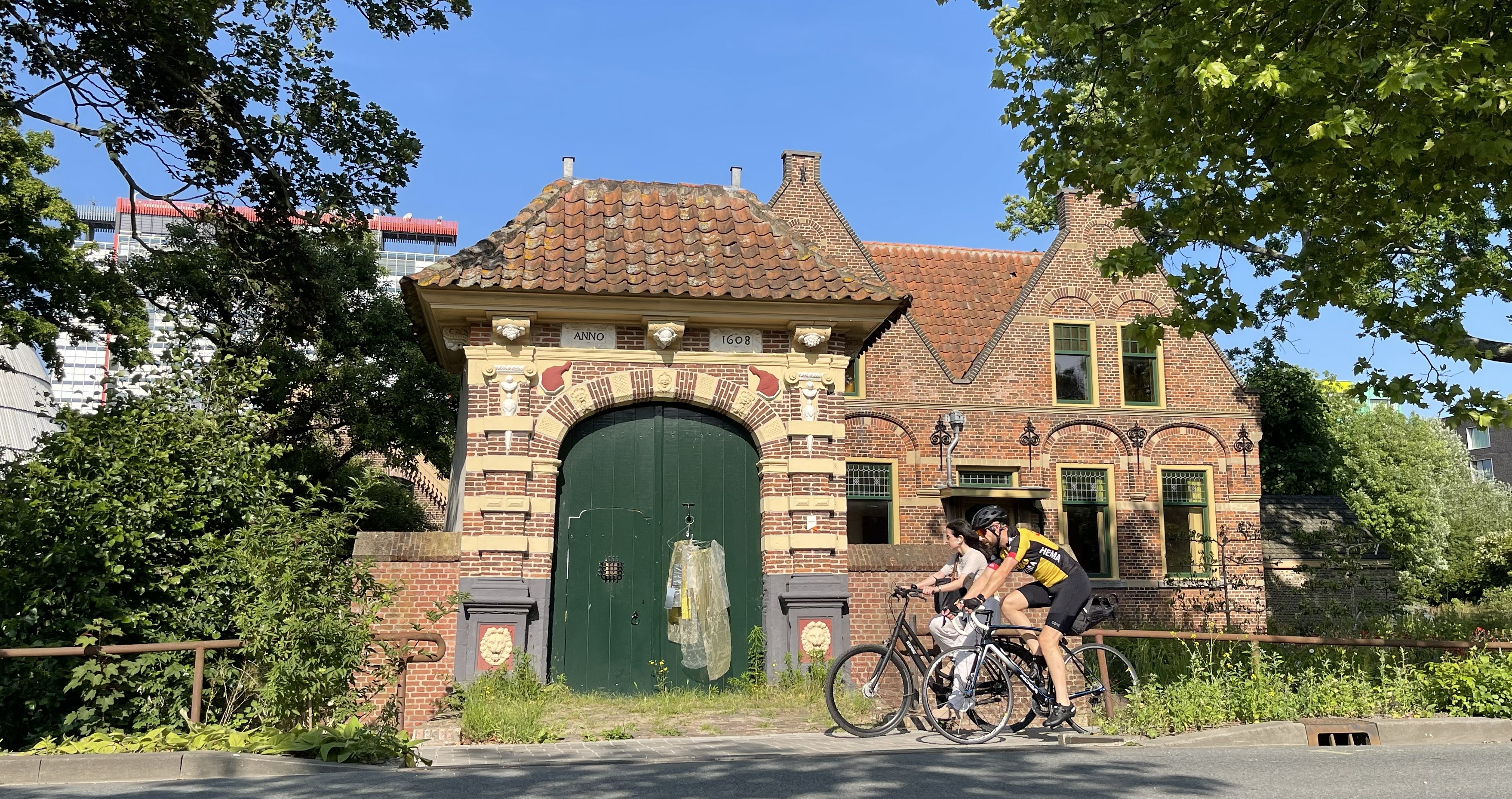 Passing Tales — Cyclists passing the historic Dutch building