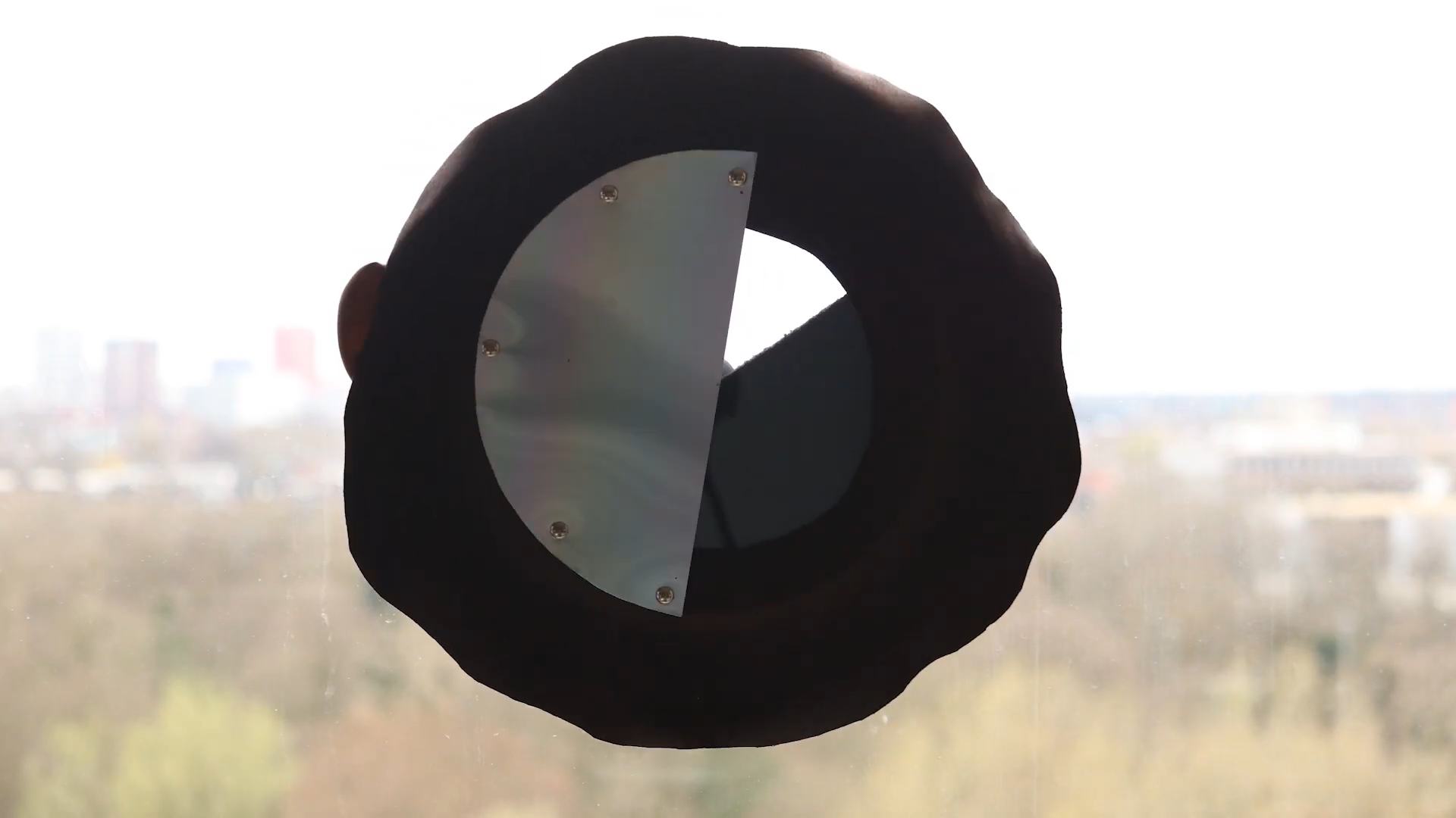 Bulaj — Iris device held against window, blades partially open