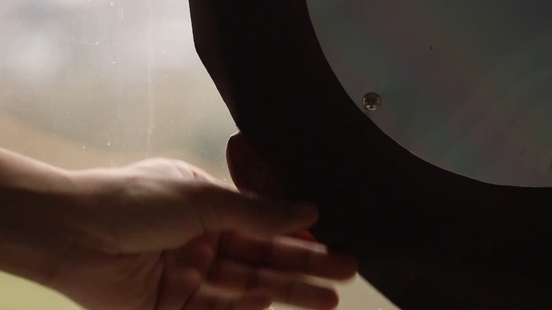 Bulaj — Close-up silhouette of hand touching the device edge