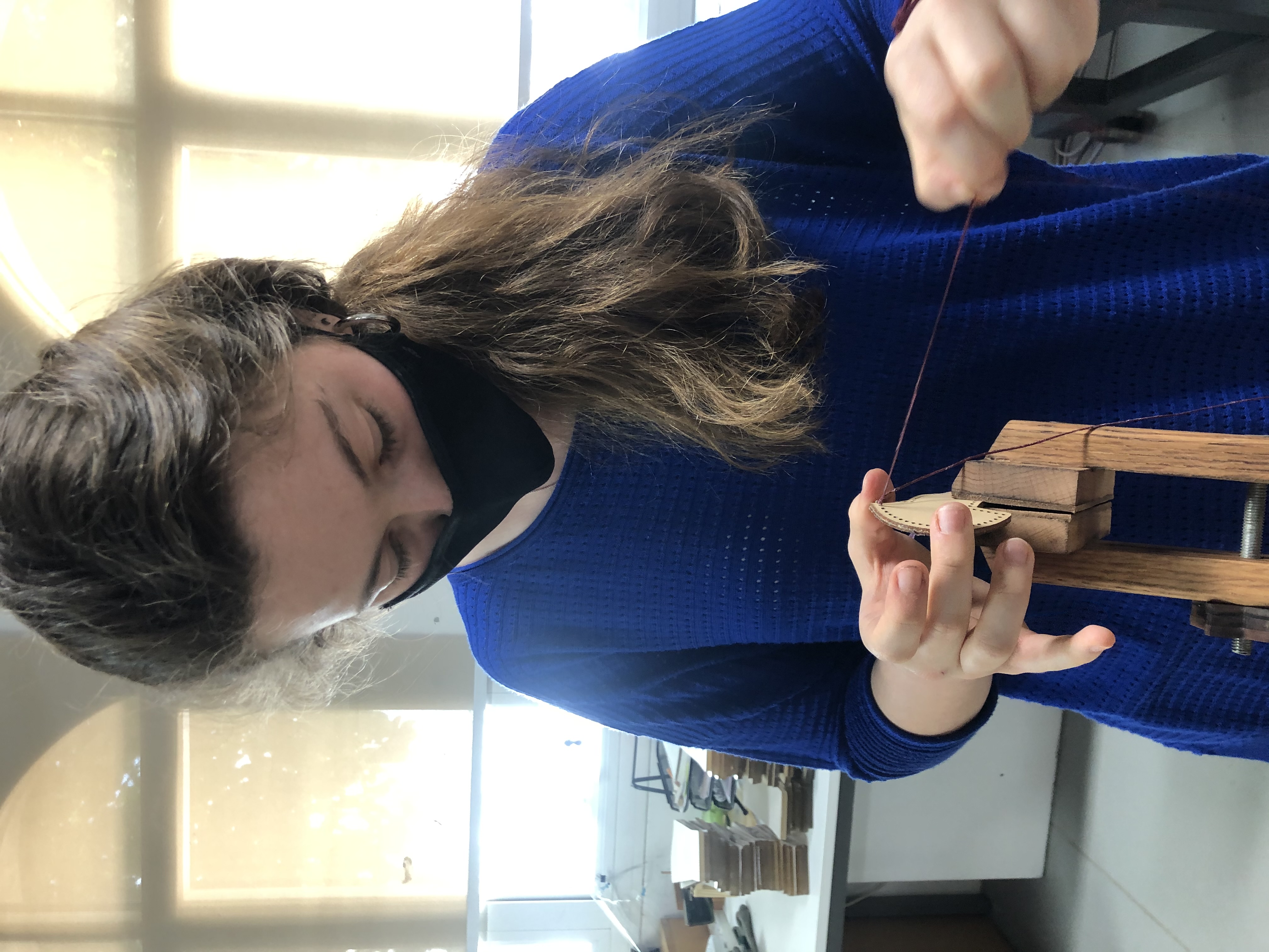 PawHaven — Hand stitching leather details in the workshop