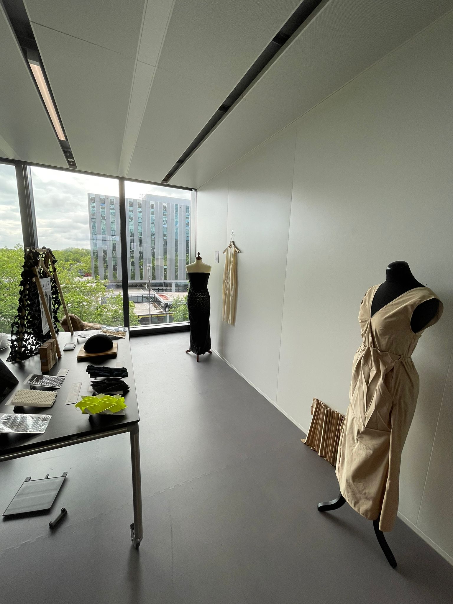 PAUX — Full exhibition display with mannequins, material samples, and garments