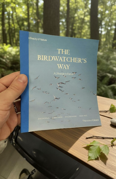 Roost Tea — The Birdwatcher's Way booklet held in a forest setting